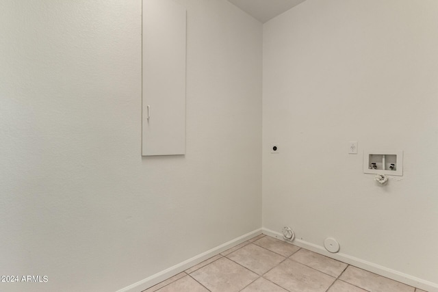 washroom with light tile patterned floors, hookup for an electric dryer, hookup for a gas dryer, washer hookup, and baseboards