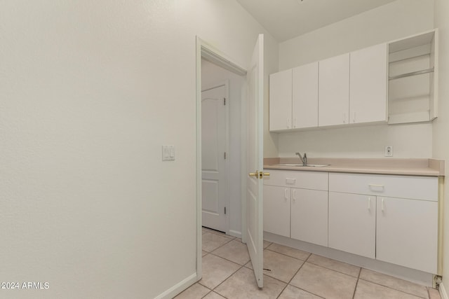 kitchen featuring sink, white cabinets, and light tile patterned floors