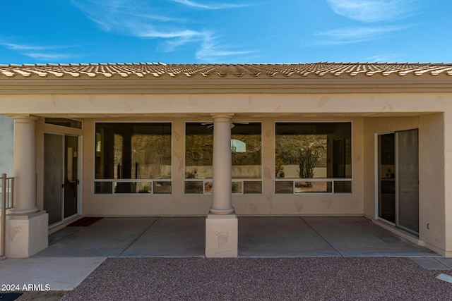 exterior space featuring a patio, a tiled roof, and stucco siding