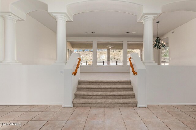 stairway with tile patterned flooring and ornate columns