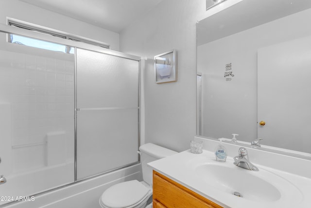 full bathroom featuring toilet, vanity, and combined bath / shower with glass door