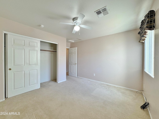 unfurnished bedroom with a closet, ceiling fan, and light colored carpet