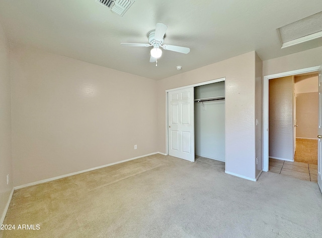 unfurnished bedroom featuring ceiling fan, light carpet, and a closet