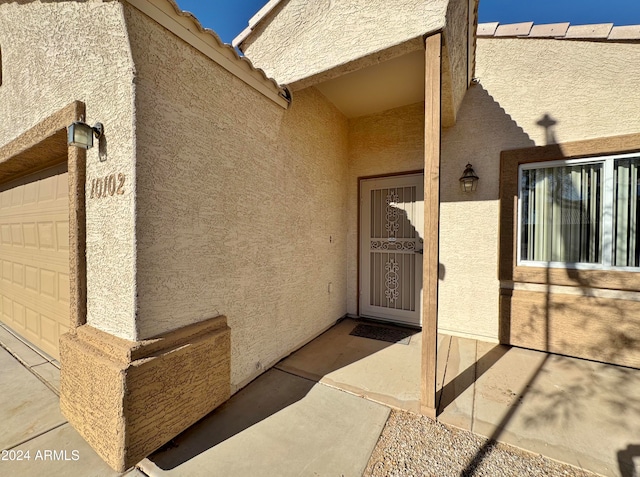 view of exterior entry with a garage