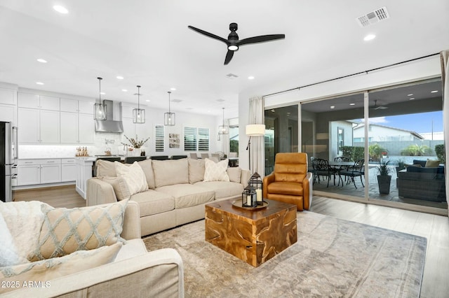 living area featuring recessed lighting, a ceiling fan, visible vents, and light wood finished floors