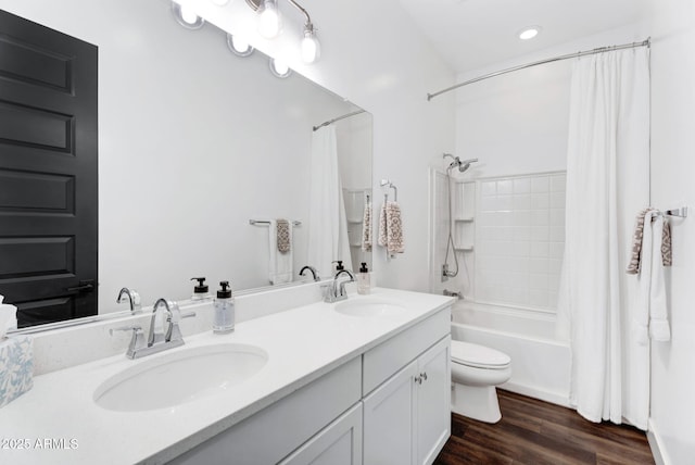 full bathroom with shower / bath combo with shower curtain, toilet, a sink, wood finished floors, and double vanity