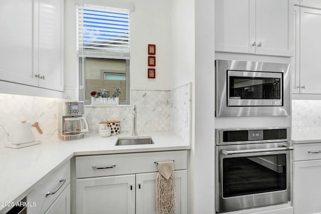 kitchen with white cabinets, appliances with stainless steel finishes, and a sink