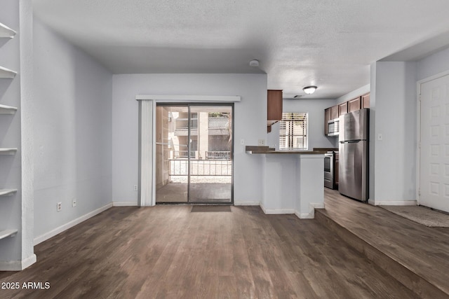 747 S Extension Rd Unit 113, Mesa, AZ 85210 - kitchen with stainless steel appliances, baseboards, dark wood-style floors, a peninsula, and a textured ceiling