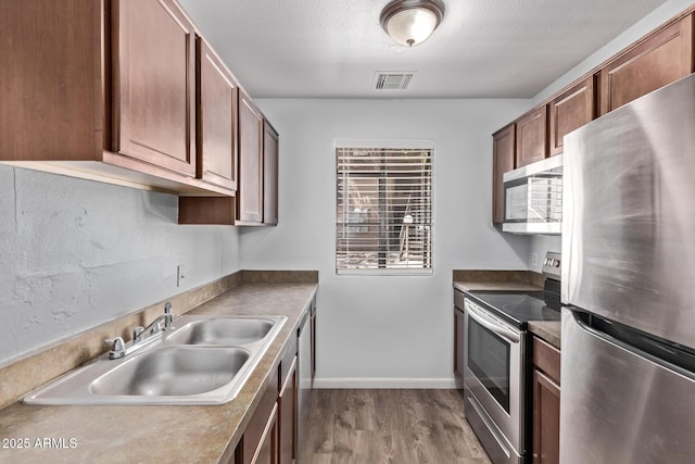 747 S Extension Rd Unit 113, Mesa, AZ 85210 - kitchen featuring appliances with stainless steel finishes, a sink, dark wood finished floors, a textured ceiling, and baseboards