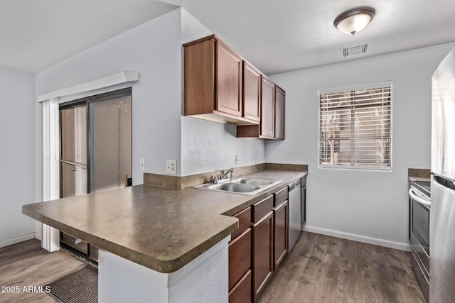 747 S Extension Rd Unit 113, Mesa, AZ 85210 - kitchen with a sink, dark countertops, dark wood-type flooring, baseboards, and a peninsula