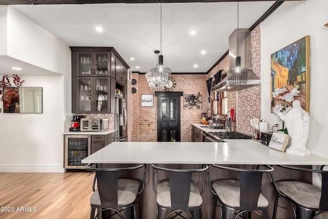 kitchen with beverage cooler, light countertops, wall chimney exhaust hood, and stainless steel refrigerator with ice dispenser