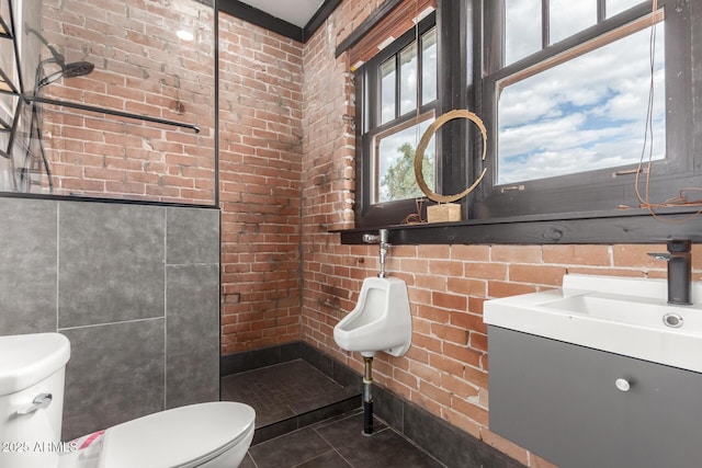 bathroom featuring tile patterned flooring, brick wall, toilet, a tile shower, and tile walls