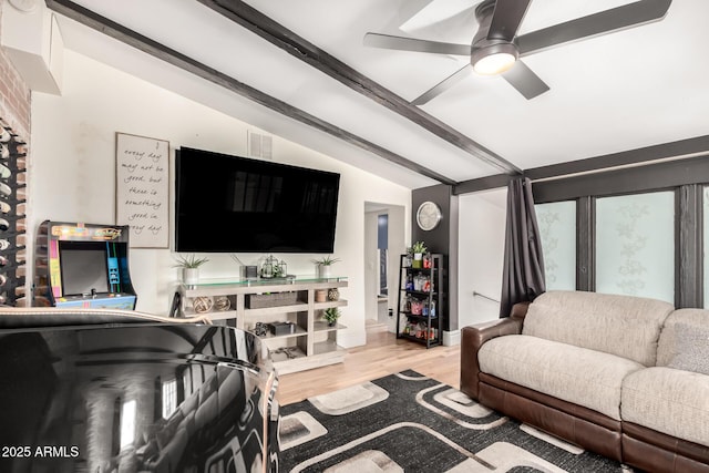 living room featuring lofted ceiling with beams, wood finished floors, and a ceiling fan