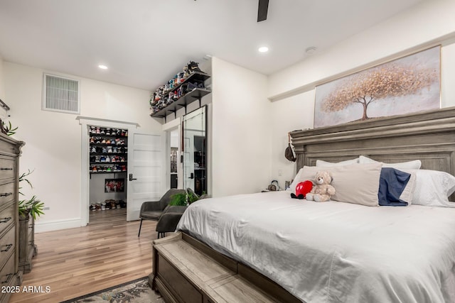 bedroom featuring a ceiling fan, visible vents, baseboards, light wood-style flooring, and recessed lighting