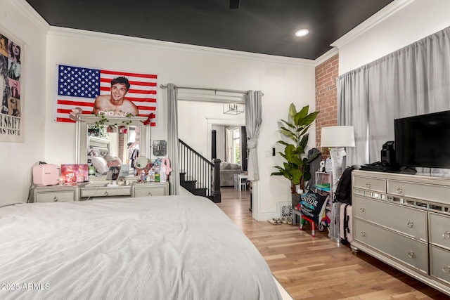 bedroom with recessed lighting, crown molding, and wood finished floors