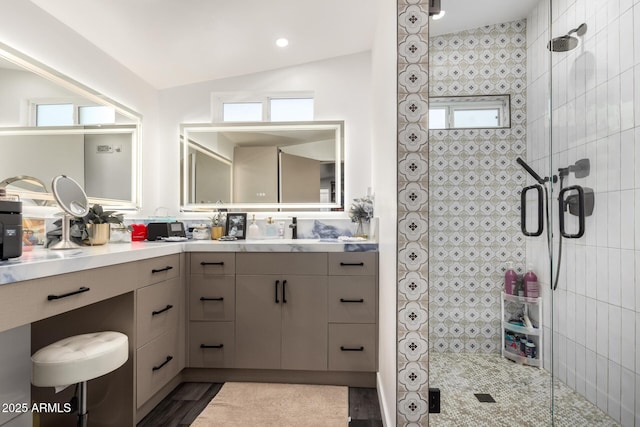 bathroom featuring vanity, vaulted ceiling, and walk in shower