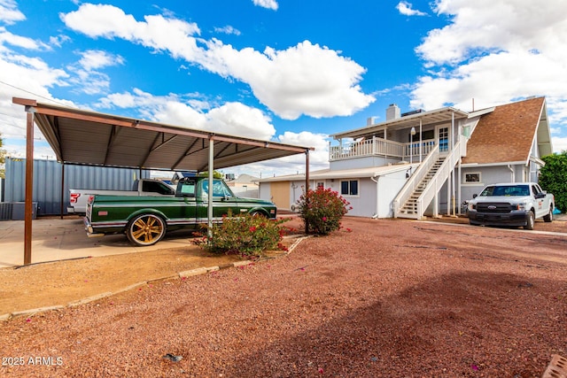 view of front facade featuring stairs and a detached carport