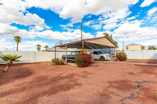 view of parking / parking lot featuring a carport and fence