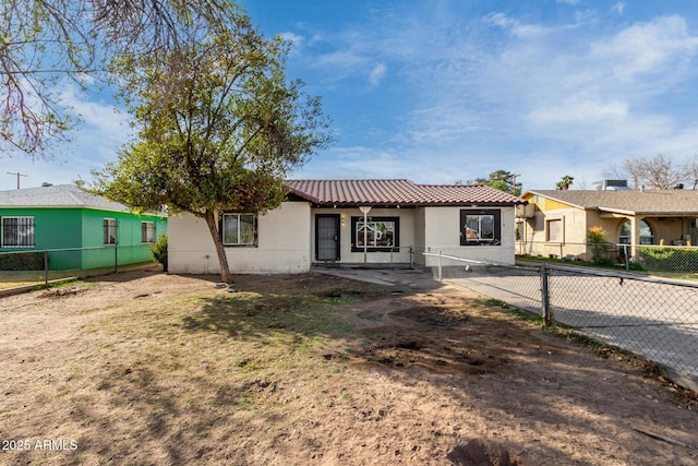 view of front of property with a tiled roof and fence