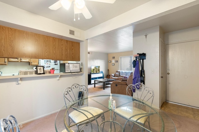 dining area with light colored carpet and ceiling fan