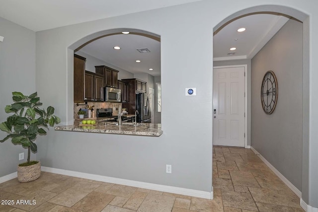 6611 S San Jacinto St, Gilbert, AZ 85298 - entrance foyer featuring stone tile flooring, baseboards, recessed lighting, and arched walkways