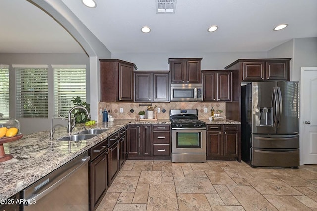 6611 S San Jacinto St, Gilbert, AZ 85298 - kitchen with stainless steel appliances, a sink, stone tile flooring, decorative backsplash, and light stone counters