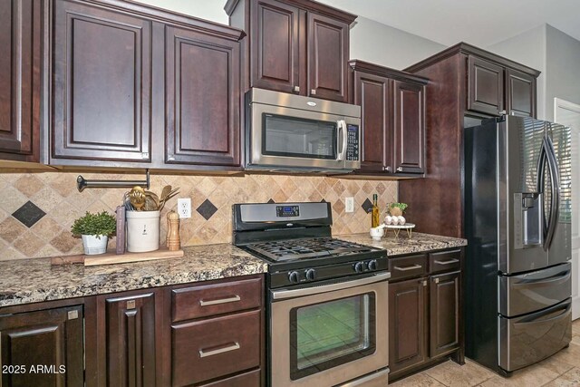 6611 S San Jacinto St, Gilbert, AZ 85298 - kitchen featuring appliances with stainless steel finishes, light stone countertops, backsplash, dark brown cabinets, and light tile patterned floors