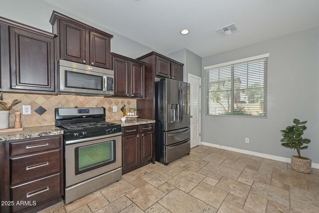 6611 S San Jacinto St, Gilbert, AZ 85298 - kitchen with appliances with stainless steel finishes, tasteful backsplash, baseboards, dark brown cabinets, and stone tile flooring