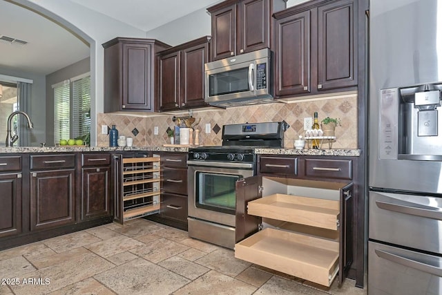 6611 S San Jacinto St, Gilbert, AZ 85298 - kitchen with stainless steel appliances, beverage cooler, arched walkways, and tasteful backsplash