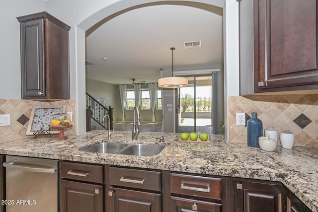 6611 S San Jacinto St, Gilbert, AZ 85298 - kitchen with arched walkways, a sink, dark brown cabinetry, and light stone counters