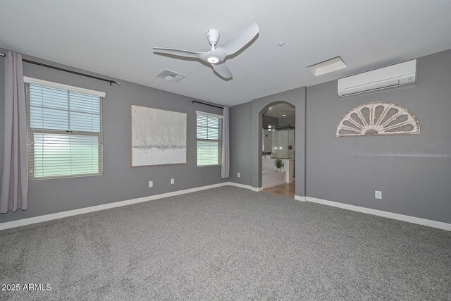 6611 S San Jacinto St, Gilbert, AZ 85298 - carpeted empty room featuring a wall mounted air conditioner, arched walkways, a ceiling fan, and baseboards