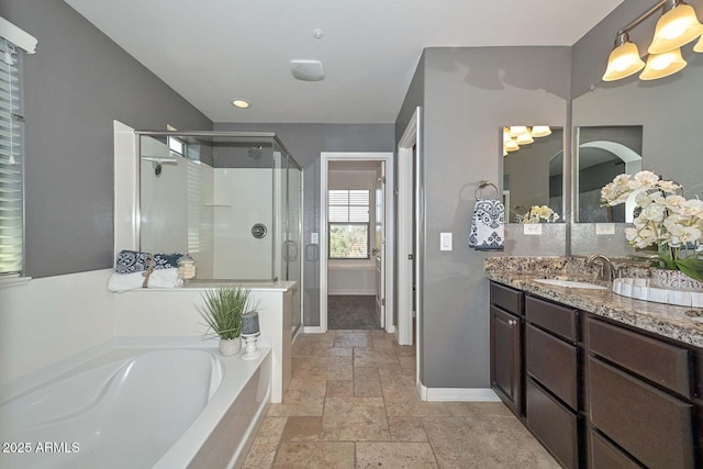6611 S San Jacinto St, Gilbert, AZ 85298 - full bathroom featuring stone tile floors, a shower stall, a garden tub, baseboards, and vanity
