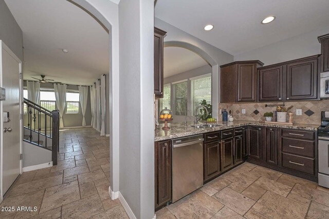 6611 S San Jacinto St, Gilbert, AZ 85298 - kitchen featuring stainless steel appliances, stone tile floors, arched walkways, baseboards, and recessed lighting