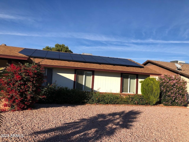 view of side of home with solar panels