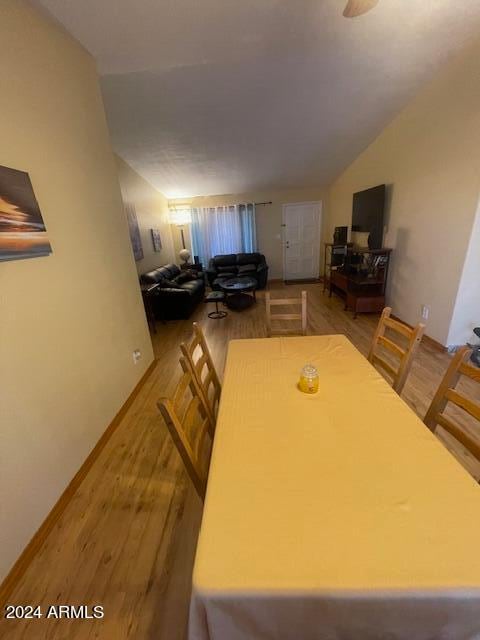 unfurnished dining area featuring hardwood / wood-style flooring and vaulted ceiling