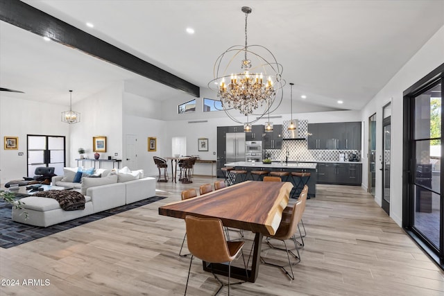 dining area featuring beam ceiling, light wood-type flooring, high vaulted ceiling, and an inviting chandelier