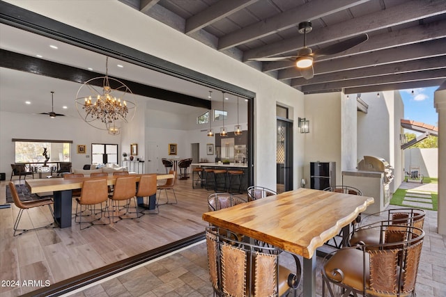 dining area with hardwood / wood-style flooring, ceiling fan with notable chandelier, lofted ceiling with beams, and wooden ceiling