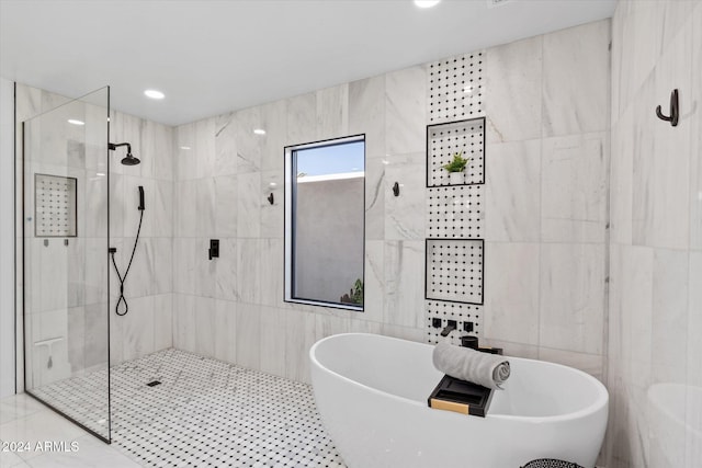 bathroom with tile patterned floors, tile walls, and independent shower and bath