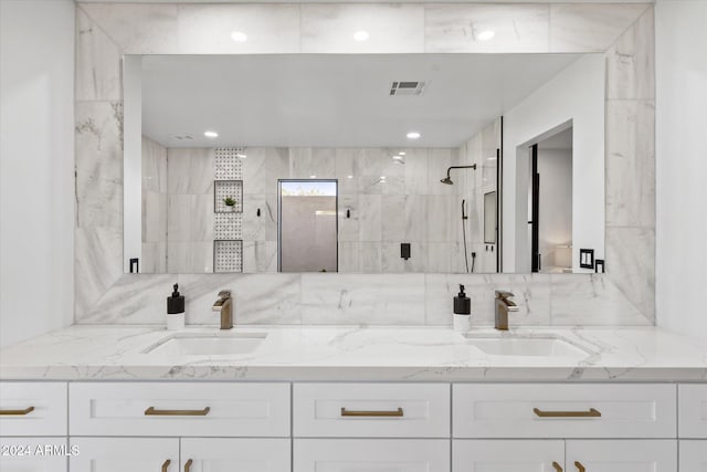 bathroom with vanity, a tile shower, and backsplash