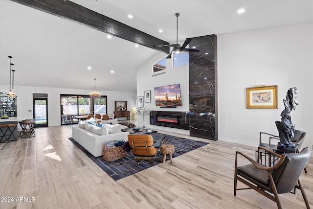 living room with light wood-type flooring, ceiling fan, beam ceiling, high vaulted ceiling, and a premium fireplace