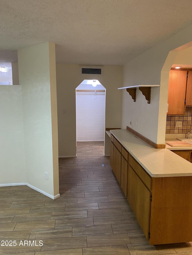 2569 W Berridge Ln Unit D-115, Phoenix, AZ 85017 - kitchen with tasteful backsplash, visible vents, open shelves, light countertops, and wood finish floors