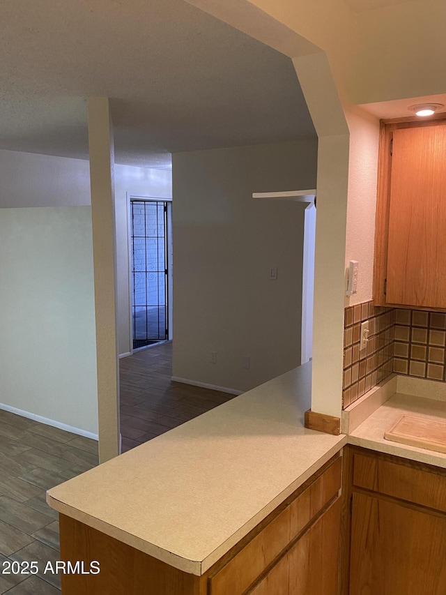 2569 W Berridge Ln Unit D-115, Phoenix, AZ 85017 - kitchen featuring light countertops, tasteful backsplash, baseboards, and a peninsula