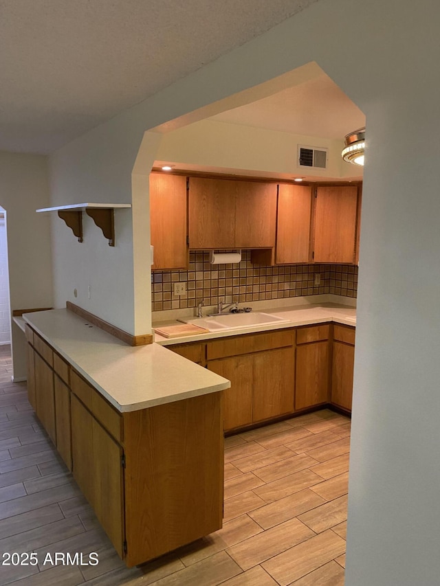 2569 W Berridge Ln Unit D-115, Phoenix, AZ 85017 - kitchen with light countertops, wood tiled floor, a sink, and backsplash