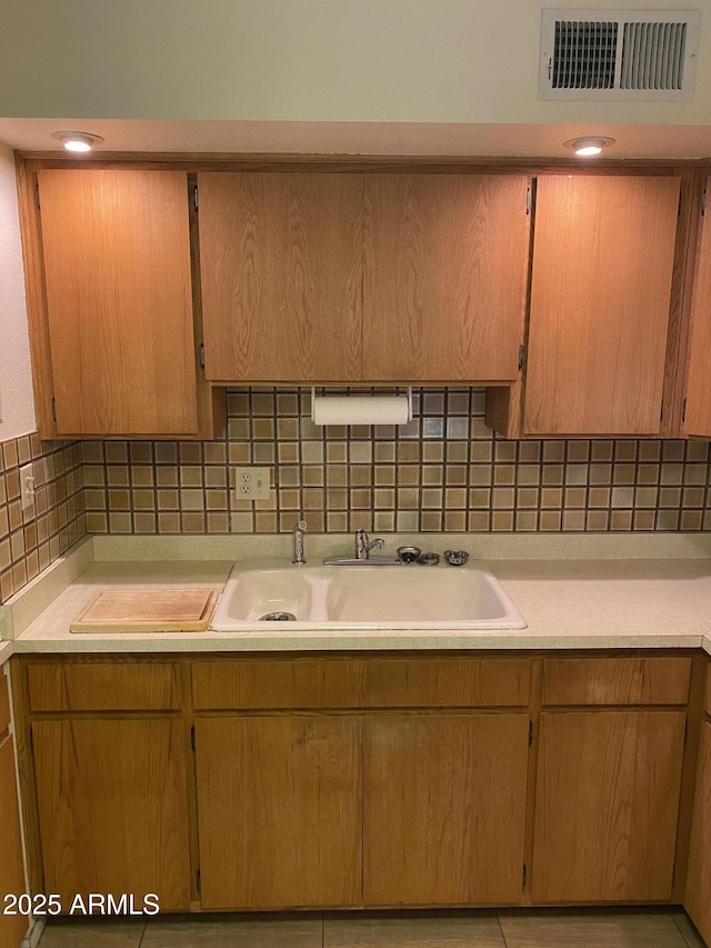 2569 W Berridge Ln Unit D-115, Phoenix, AZ 85017 - kitchen with decorative backsplash, a sink, visible vents, and light countertops
