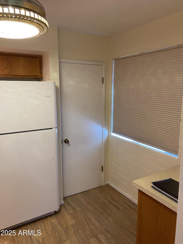 2569 W Berridge Ln Unit D-115, Phoenix, AZ 85017 - kitchen featuring light countertops, wood finished floors, freestanding refrigerator, and brown cabinets