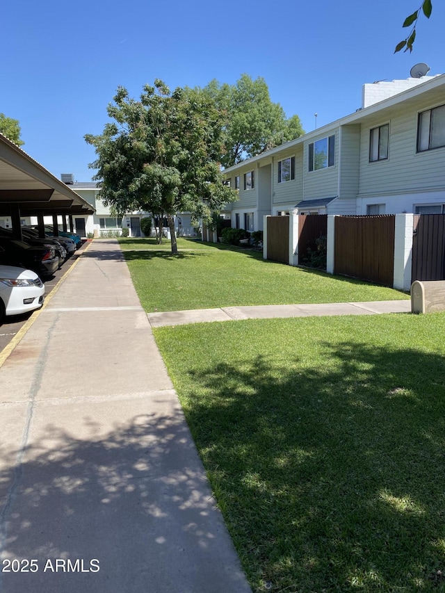 2569 W Berridge Ln Unit D-115, Phoenix, AZ 85017 - view of property's community with fence, a lawn, and covered parking