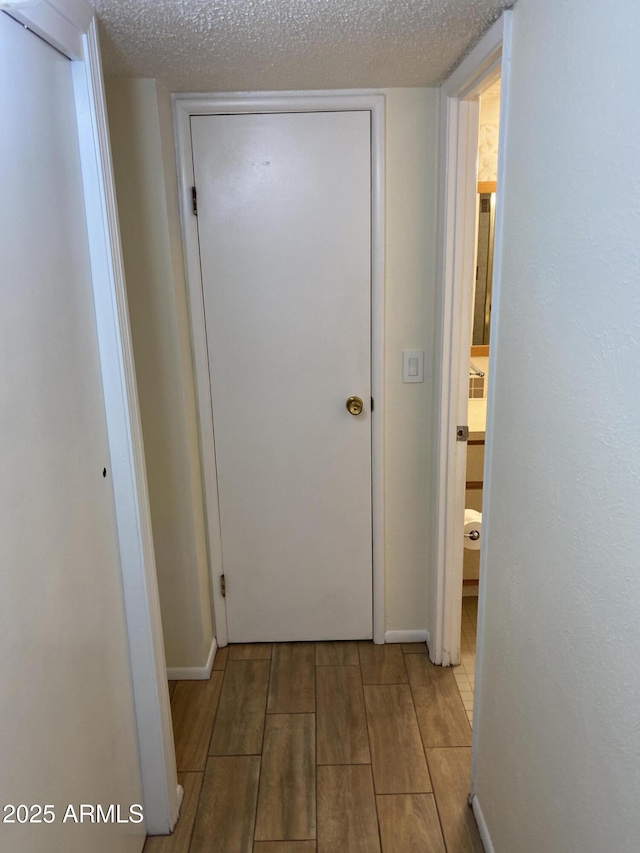 2569 W Berridge Ln Unit D-115, Phoenix, AZ 85017 - corridor with baseboards, wood finished floors, and a textured ceiling