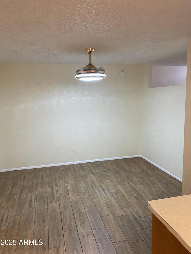 2569 W Berridge Ln Unit D-115, Phoenix, AZ 85017 - unfurnished dining area featuring baseboards, a textured ceiling, and dark wood-style floors