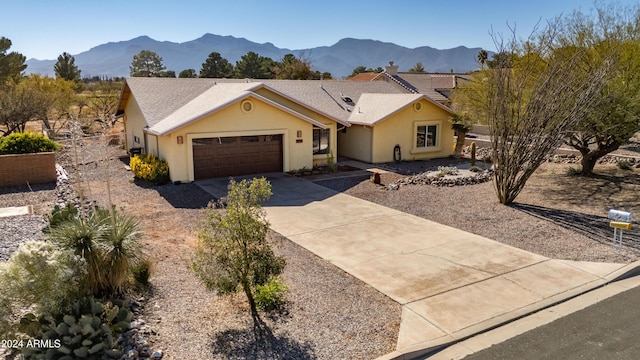 single story home with a mountain view and a garage