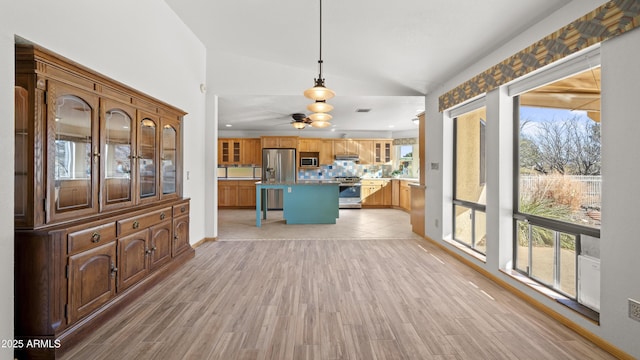 unfurnished living room with ceiling fan, light hardwood / wood-style flooring, and vaulted ceiling